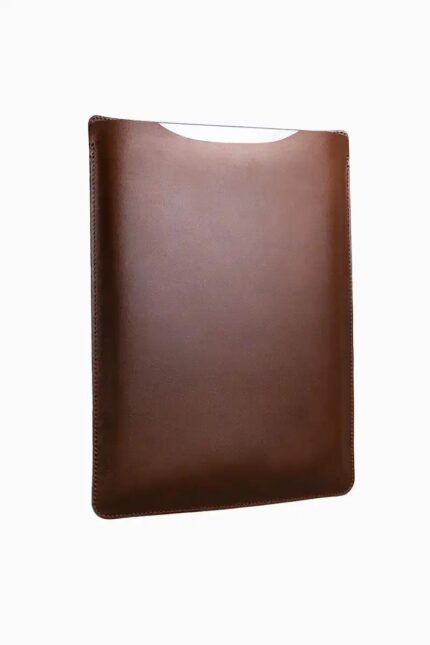 Vintage brown leather MacBook sleeve with patina finish, displayed at angle showing aged leather surface and protective curved shape