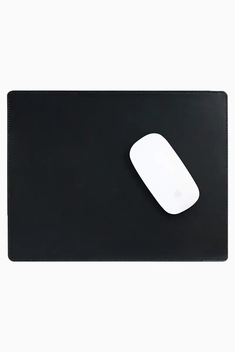 Black leather mouse pad with tone-on-tone perimeter stitching and rounded corners, with a white wireless mouse placed on the right side, top-down view on a white background.